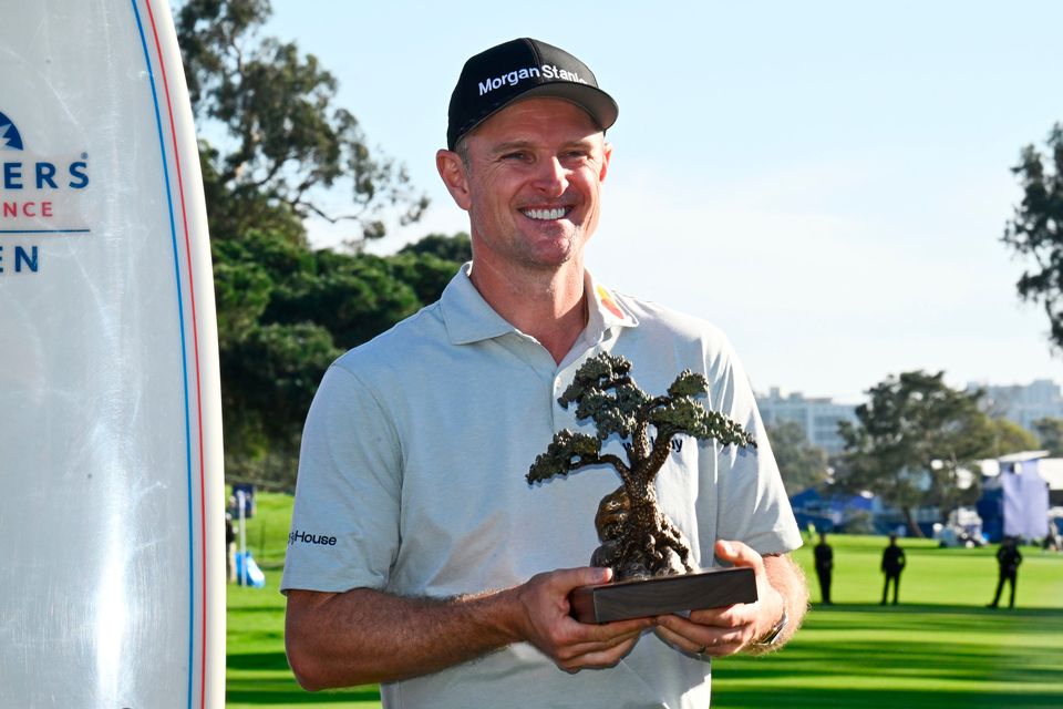 Justin Rose holds the winner's trophy at the Farmers Insurance Open golf tournament at Torrey Pines in San Diego. (AP Photo/Denis Poroy)